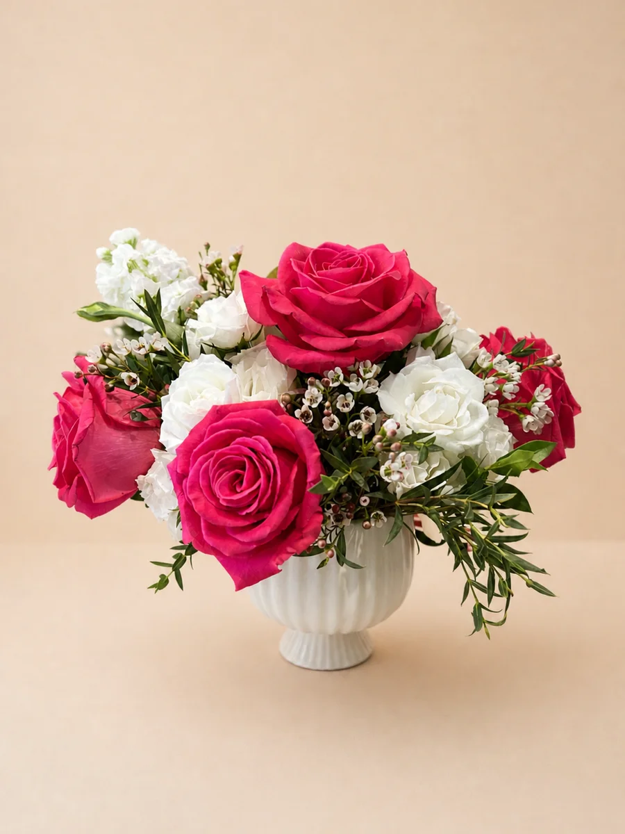 The Juliette - hot pink roses and spray roses with wax flowers and eucalyptus in a white scalloped vase